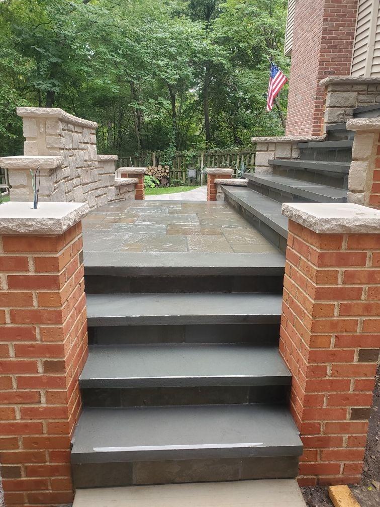 Pillars and steps. Brick pillars with limestone caps beside new stone steps.