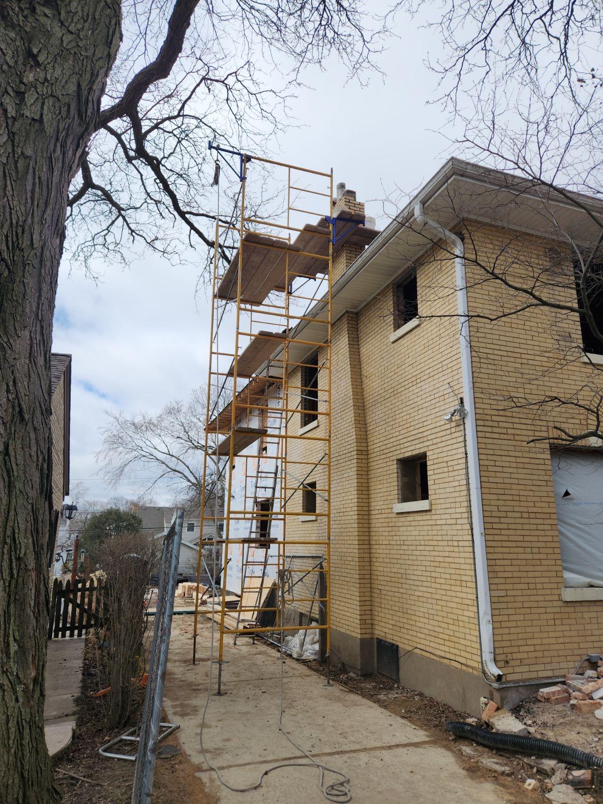 Two-story chimney. Scaffolding up for chimney work on a two-story house.
