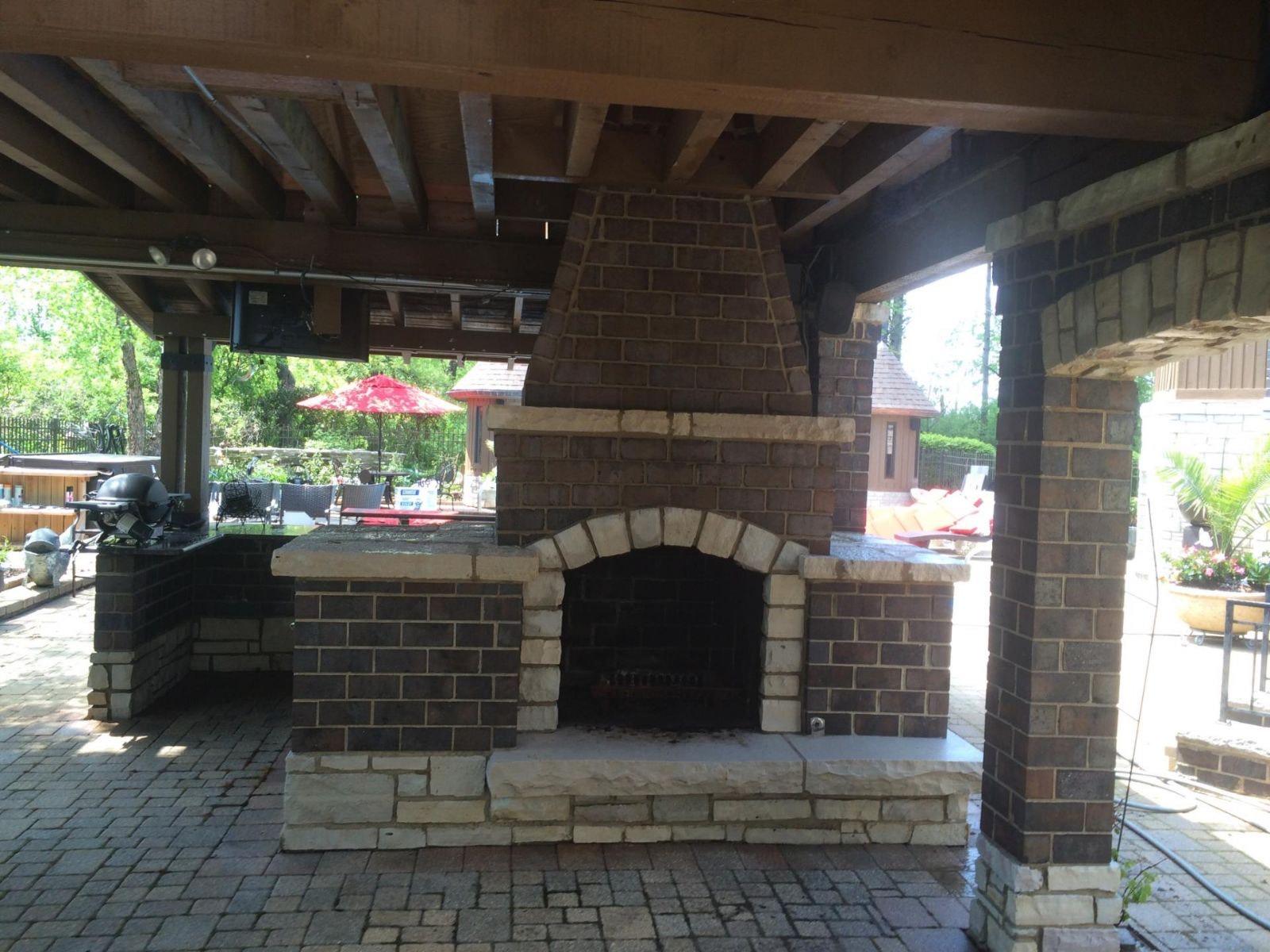 Covered brick fireplace. Brick fireplace with stone accents under a covered patio.