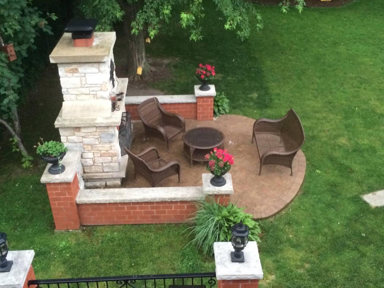 Fireplace and seat wall. Stone fireplace with a brick seat wall and pillars.