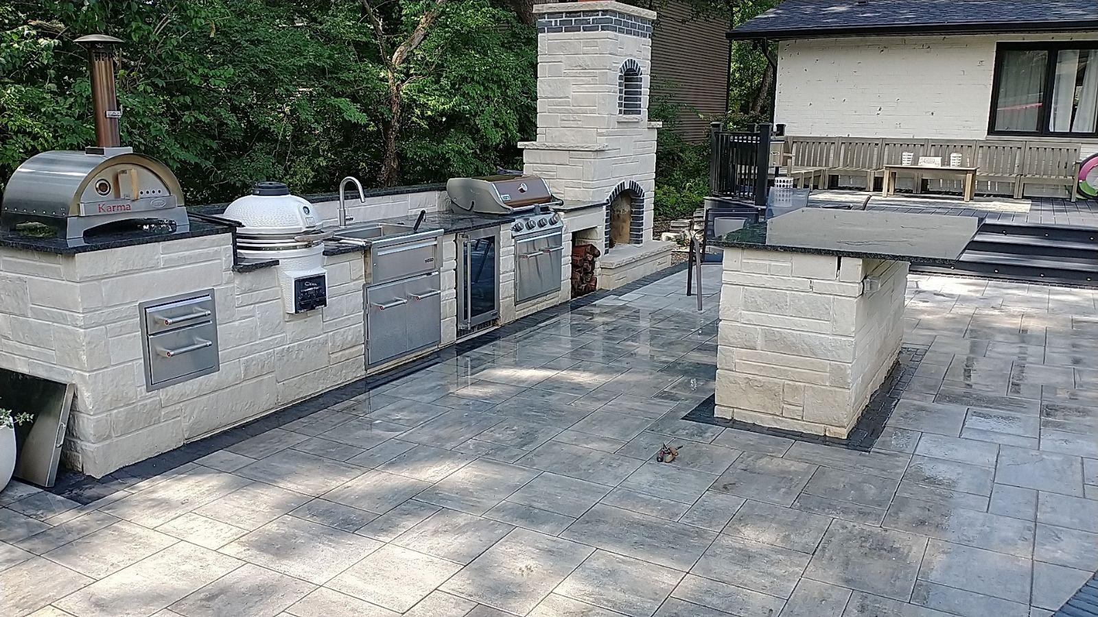 Outdoor kitchen. Stone outdoor kitchen with built-in grills, a bar island and a fireplace.