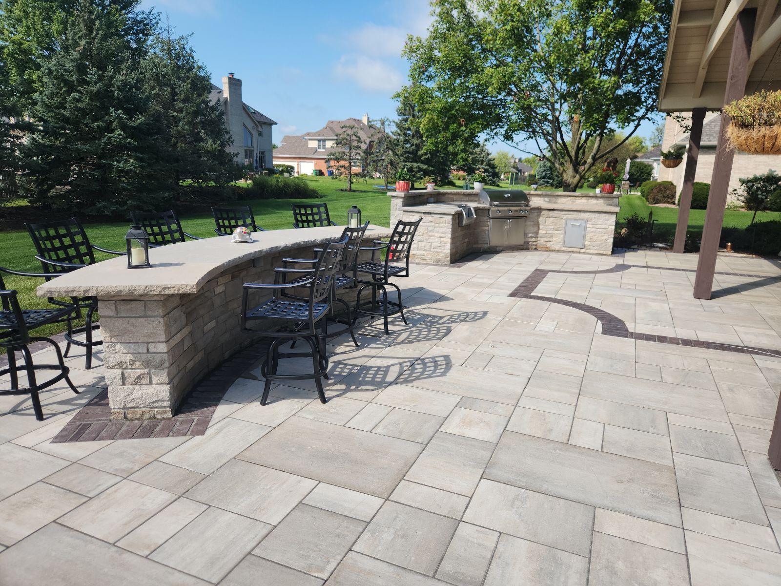 Curved stone bar. A curved stone bar and seat wall wrapped around a paver patio.