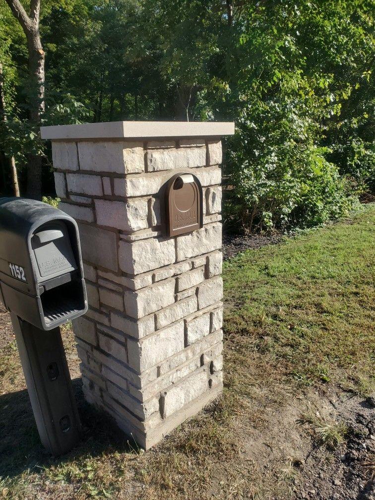 Stone mailbox pillar. Stone pillar with a built-in mailbox and limestone cap.