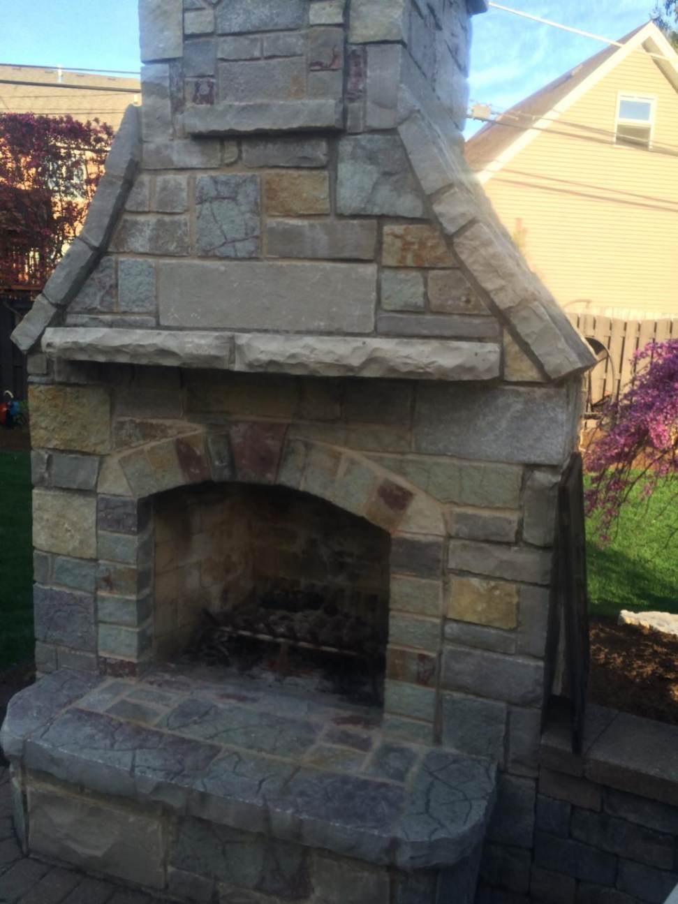 Stone outdoor fireplace. Natural stone fireplace with an arched firebox.